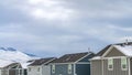 Panorama Row of homes against snow covered mountain under the cloud filled sky Royalty Free Stock Photo