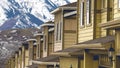 Panorama Row of homes with snow covered mountain and sky in the background Royalty Free Stock Photo