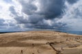 Panorama of sand dunes and blue sea. Seascape with people resting and walking near the sea on a summer day. Royalty Free Stock Photo