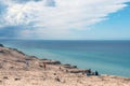 Panorama of sand dunes and blue sea. Seascape with people resting and walking near the sea on a summer day. Royalty Free Stock Photo