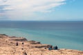 Panorama of sand dunes and blue sea. Seascape with people resting and walking near the sea on a summer day. Royalty Free Stock Photo