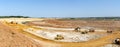 Panorama of the sand quarry. Extraction of sand in the quarry. Backhoe loading sand into dump trucks.