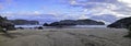Panorama. Sandy ocean coast with large rocks in the water. Royalty Free Stock Photo