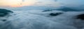 Panorama of sea of clouds around mountain peaks at sunrise Royalty Free Stock Photo