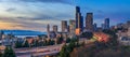 Panorama of Seattle downtown skyline beyond the I-5 I-90 freeway interchange at sunset with long exposure traffic trail lights