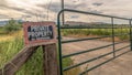 Panorama Security gate and fence with No Trespassing sign against mountain and cloudy sky Royalty Free Stock Photo