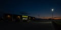 Panorama shot of exterior of a Dollar General at night as customers park in the parking lot Royalty Free Stock Photo