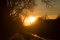 Panorama with silhouette of suspended bridge under the channel and trees silhouettes by sunset