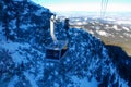 Panorama of ski resort, slope, people on the ski lift, skiers on the piste among white snow pine trees