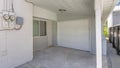 Panorama Small garage at the side of a house with white siding and two electricity meters