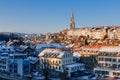 Panorama of snow-covered roofs of Bern`s old town and Steeple of Berne Cathedral.