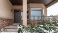 Panorama Snowy evergreens beside stairs that leads to porch of home with front bay window