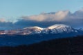 Panorama of snowy mountains at sunset. Majestic clouds over the mountains