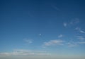 Panorama of soft wind swept white clouds and moon in blue sky. Royalty Free Stock Photo