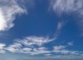 Panorama of soft wind swept white clouds and moon in blue sky. Royalty Free Stock Photo