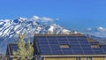 Panorama Solar panels installed on the roof of home against snowy mountain and blue sky Royalty Free Stock Photo