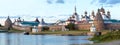 Panorama of the Solovetsky monastery with blue sea bay in the foreground at sunset, temples, towers, surrounding wall