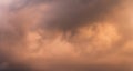 Panorama of stormy sky at twilight with clouds in various shades of orange and gray