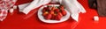 Panorama with strawberries and sugar on a glossy red table