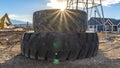 Panorama Sun in the cloudy blue sky shining brightly behind a pile of old rubber tires