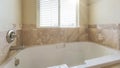 Panorama Sun flare Alcove bathtub in a bathroom with matte marble tiles surround Royalty Free Stock Photo