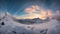 Panorama of sunrise over snowy mountain range with mountaineer tent camping in winter on Segla Mount at Senja Island