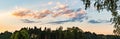 Panorama, sunset over fields and Austrian village with dramatic sky and colorful clouds