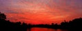 Panorama sunset in red sky beautiful colorful landscape silhouette tree woodland and river reflect the twilight time Royalty Free Stock Photo