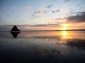 Panorama sunset reflection of Paratahi Island rock on black sand Karekare Beach West Auckland North Island New Zealand Royalty Free Stock Photo