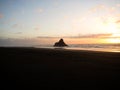 Panorama sunset view of Paratahi Island rock on black sand Karekare Beach West Auckland North Island New Zealand Royalty Free Stock Photo