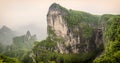 Panorama of the Tianmen Mountain Peak with a view of the cave Known as The Heaven`s Gate surrounded by the green forest and mist