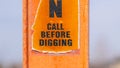 Panorama A torn Caution sign on a bright orange post against a blurry background