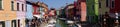 Panorama of tourists on a canal with brightly painted houses