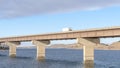 Panorama Truck on a stringer bridge acroos blue lake overlooking hills and cloudy sky Royalty Free Stock Photo