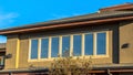 Panorama Upper storey of a house lined with rectangular windows against clear blue sky