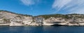 Panorama of vertical white rocks with vegetation against the sea and sky with clouds Royalty Free Stock Photo