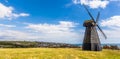 A panorama view across Beacon Hill towards a smock windmill and the town of Rottingdean, Sussex, UK