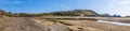 A panorama view across the stream and the beach at Three Cliffs Bay, Gower Peninsula, Swansea, South Wales Royalty Free Stock Photo