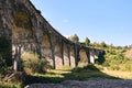 Panorama view of ancient bridge. Viaduct with old railway tracks near green hill of mountain forest. Locat travel concept Royalty Free Stock Photo