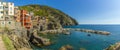 A panorama view of colourful houses and crystal clear waters in the Cinque Terre village of Riomaggiore, Italy Royalty Free Stock Photo