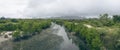 Panorama view of crack earth and dry water among mangrove forest with sky, rainy clouds float on top of big and long mountain Royalty Free Stock Photo