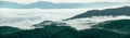 Panorama view of foggy mountain landscape. Aerial view of dark green trees in mountain forest and fog in winter. Fog covered dark Royalty Free Stock Photo