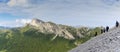 Panorama of a group of mountain climbers hiking up a mountain side to a hard climbing route