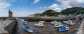 Panorama view of the harbor and village of Lynmouth in North Devon with many boats stuck at low tide