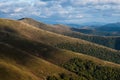 Panorama of a view of hills of a smoky mountain range covered in white mist and deciduous forest under blue cloudless sky on a Royalty Free Stock Photo