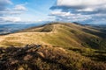 Panorama of a view of hills of a smoky mountain range covered in white mist and deciduous forest under blue cloudless sky on a Royalty Free Stock Photo