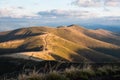 Panorama of a view of hills of a smoky mountain range covered in white mist and deciduous forest under blue cloudless sky on a Royalty Free Stock Photo