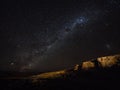 Panorama view of milkyway stars in dark night sky above cliff rock formation in Uyuni Sur Lipez Bolivia South America