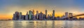 Panorama view of New York City downtown skyline and Brooklyn bridge at sunset