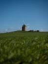 Panorama view of old rustic historic windmill Moulin de Moidrey in green grass field meadow Pontorson Normandy France